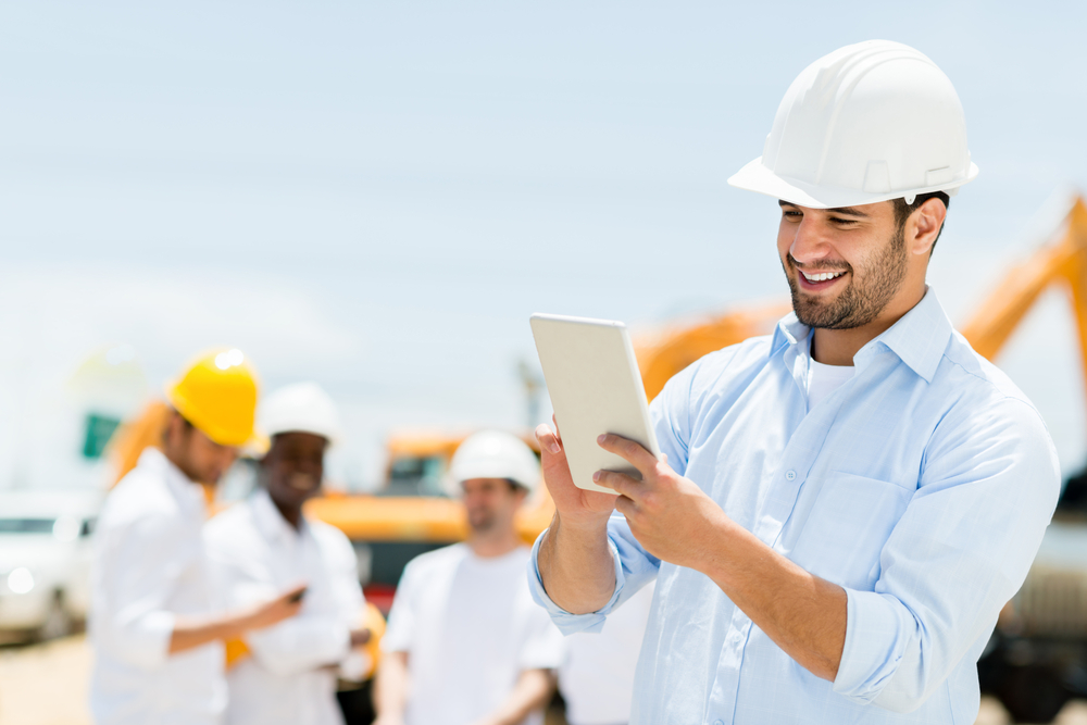 Male engineer at a construction site with a tablet computer